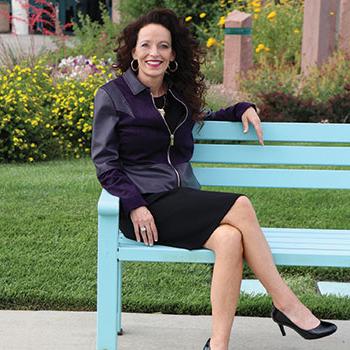 President Dr. Pendergrass sitting on a bench outside of the Henderson Fine Arts Center